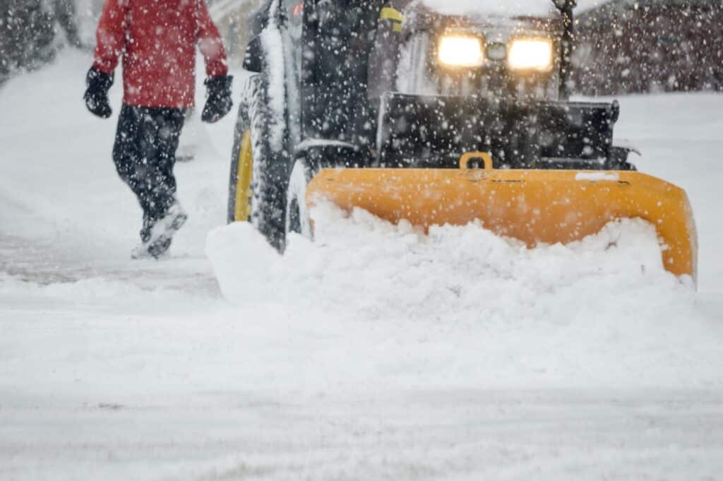 A snow plow clearing a parking lot in Albany NY